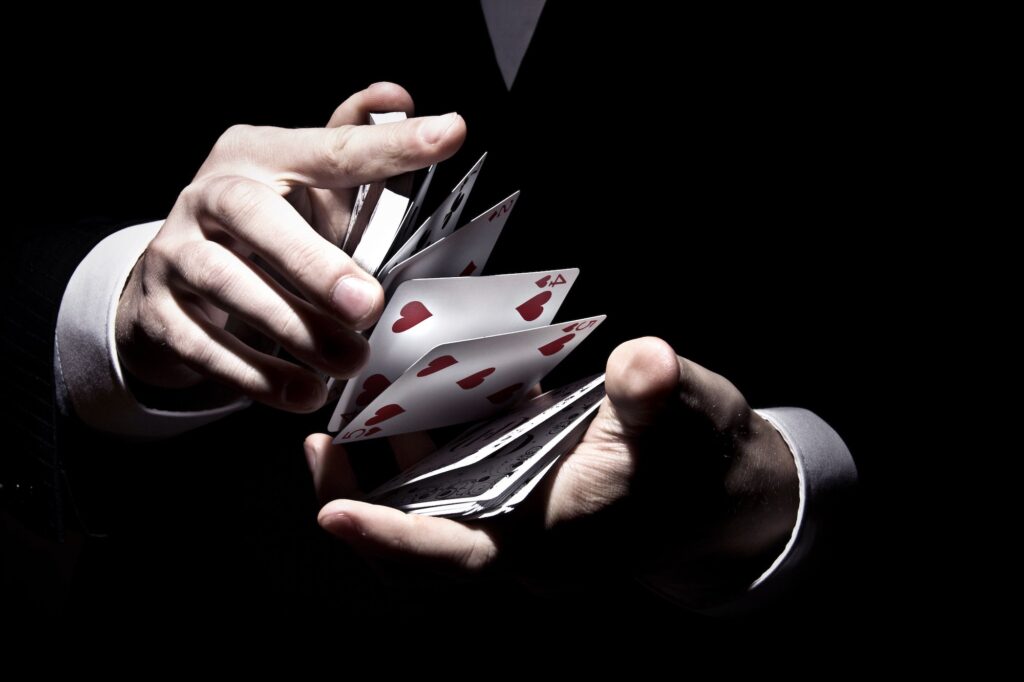 Magician shuffling the cards in a cool way under the spotlight